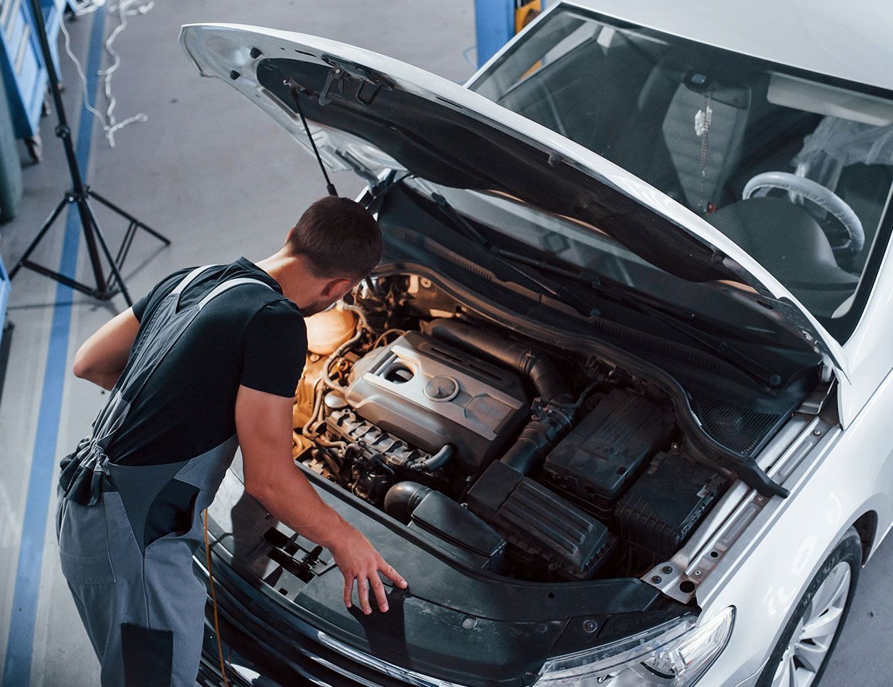 Ein Mann überprüft einen Automotor - Draufsicht