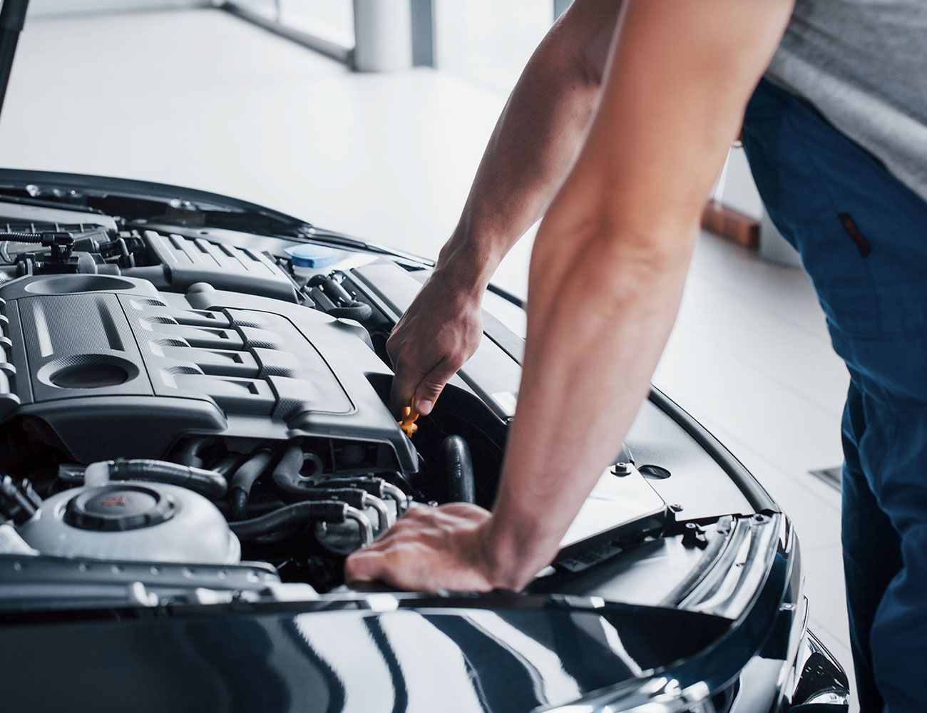 Eine Person prüft den Ölstand in einem Auto